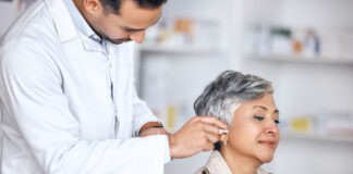 Hörprobleme im Alter Ohrenuntersuchung an einer Frau