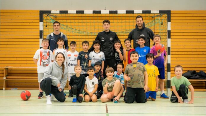 Gruppenbild mit Schülern und Holstein-Spieler Hamza Muqaj