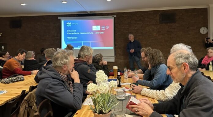 Zuhörerinnen und Zuhörer im Vereinslokal des SV Hammer hören Energieberater Jasper Harten zu, der Mustersanierungskonzepte vorstellt