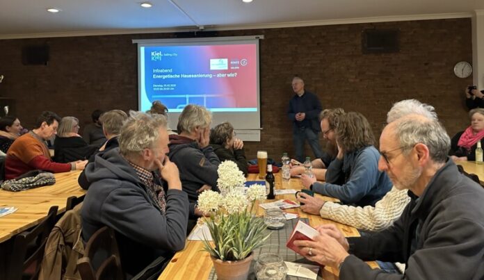 Zuhörerinnen und Zuhörer im Vereinslokal des SV Hammer hören Energieberater Jasper Harten zu, der Mustersanierungskonzepte vorstellt