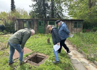 Birger Kulbe stellvertretender Vorsitzender des Kleingartenvereins und Hobbyhistoriker Heidi Kjär und Bernd Vesper begutachten den rätselhaften Schacht im Vieburger Gehölz