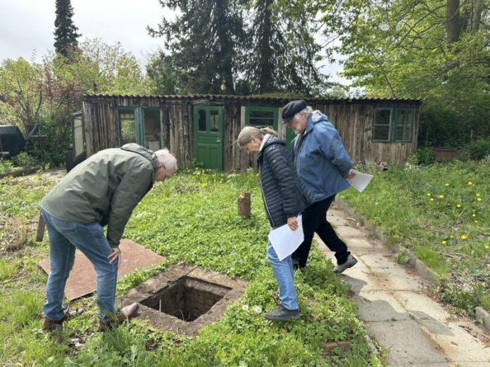 Birger Kulbe stellvertretender Vorsitzender des Kleingartenvereins und Hobbyhistoriker Heidi Kjär und Bernd Vesper begutachten den rätselhaften Schacht im Vieburger Gehölz