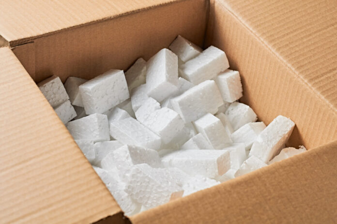 Open square cardboard box for parcels full of rectangular styrofoam blocks Box mit Styropor