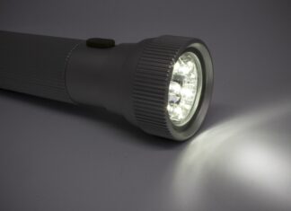 Wie lange halten die Akkus? Angeschaltete Taschenlampe auf Oberfläche